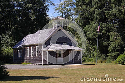 Old schoolhouse with flagpole Stock Photo