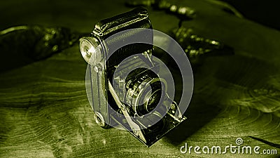 Old scratched and dusty antique photo camera, with foldable original Carl Zeiss Lens, on a rustic wooden table. Editorial Stock Photo