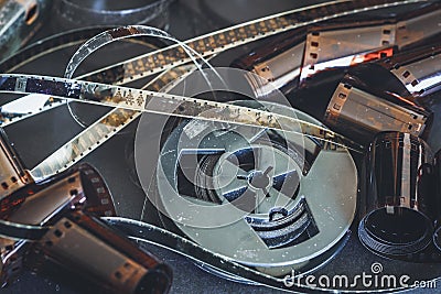 Old scratched 8 mm and 16mm film strips, bobbin, retro film and photo. Vintage background Stock Photo