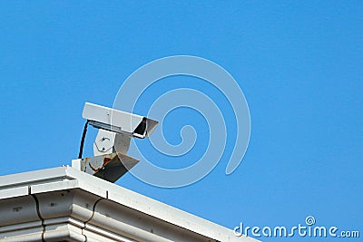 an old Security camera watching the safety for everyone from high place at public park. Stock Photo