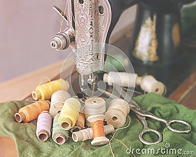 Old sewing machine, scissors and vintage spools of thread, closeup. Stock Photo