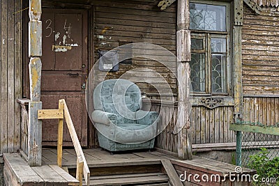 Chair on entrance porch of vintage wooden city house with carved wooden elements Stock Photo