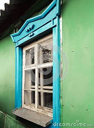 Old shabby retro vintage window with blue painted trim on green Stock Photo