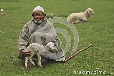 Old shepherd holding a baby goat Editorial Stock Photo