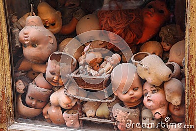 Old showcase with many old heads dolls Stock Photo