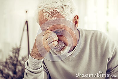 Old sick grey-haired man in beige sweater feeling terrible pain Stock Photo