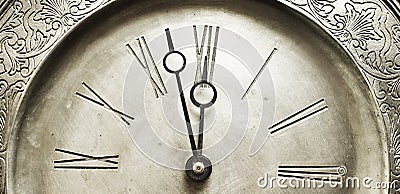 Old silver clock with roman numbers indicating it's about time. Stock Photo