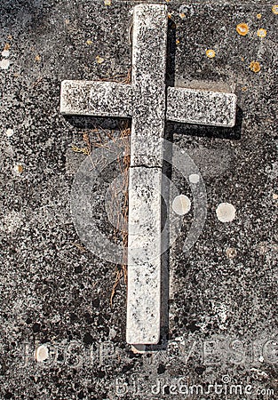 Old simple cross standing on a grave, bent and ruined over time. Hunders of years old on a christan graveyard Stock Photo