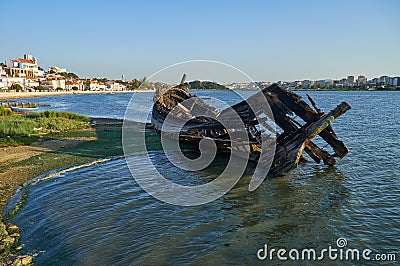 Old skeleton of a destroyed and burned boat on the bank of the S Stock Photo