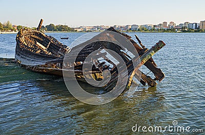 Old skeleton of a destroyed and burned boat on the bank of the Seixal Bay. Lisbon. Portugal Stock Photo