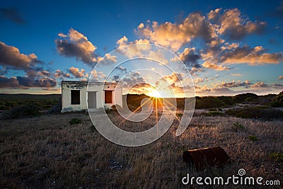 Old small deserted house in field with cloud sunset landscape Stock Photo