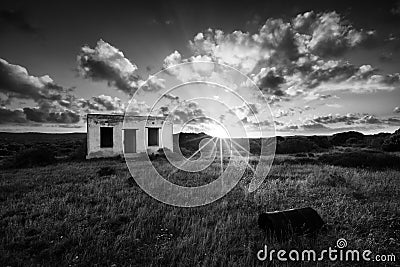 Old small deserted house in field with cloud sunset landscape ar Stock Photo