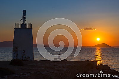 Old small lighthouse of the Aegina island, Saronic gulf, Greece, at sunset Editorial Stock Photo