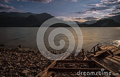 Old solitary boat wood destroyed aground in a lonely beach lake Stock Photo