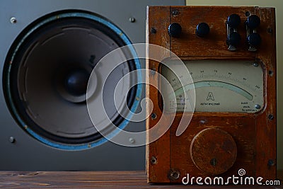 Antique wooden ammeter against the background of an antique broadband speaker. Stock Photo
