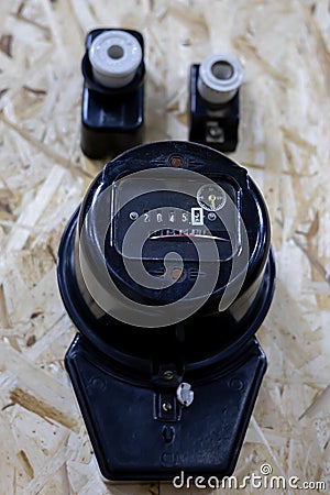 An old Soviet black electric meter hangs on the wall. Retro items from the past Stock Photo