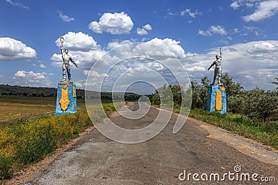 The old Soviet sculpture Worker and Collective Farm on road offers entry into a dying Ukrainian village. Old Soviet monument, Stock Photo