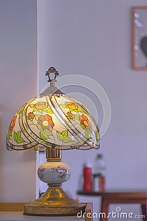 The Old Stained Glass Tiffany Table Lamp with blurred background of Interior white wall of Vintage Restaurant in Vertical frame Stock Photo