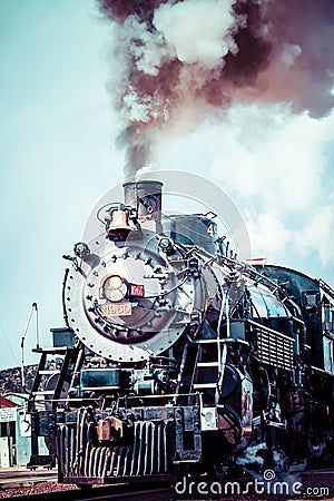 Old steam locomotive against blue cloudy sky, vintage train Editorial Stock Photo