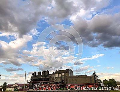 Old steam locomotive on a cloudy blue sky background Editorial Stock Photo