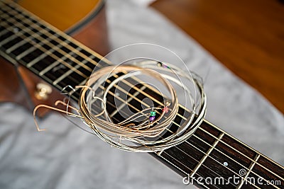 Old steel guitar strings on acoustic guitar neck Stock Photo