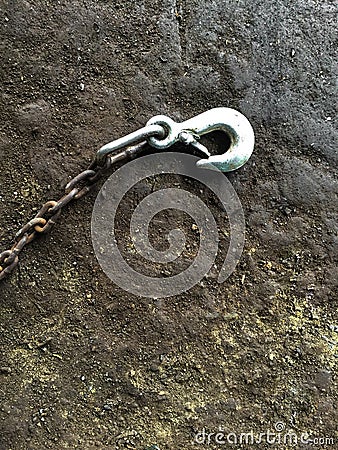 Old steel hook on dirty old cement floor Stock Photo