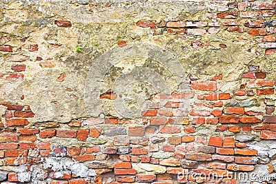 Old stone and brick wall with degraded plaster Stock Photo