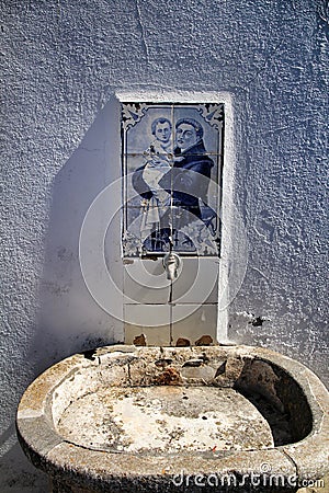 Old stone fountain with blessed water by saint Stock Photo