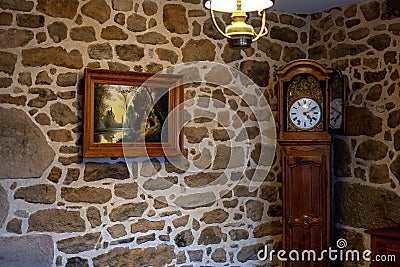 Old Stone house with vintage antique clock, decorative lamp and picture on the wall. Antique background Stock Photo