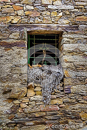 Old stone house window with nets used in ancient agriculture. La Hiruela Madrid Stock Photo