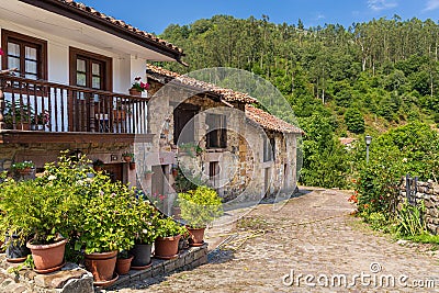 Old stone mountain mansions with balconies and flowers. Carmona, Cantabria, Spain Stock Photo
