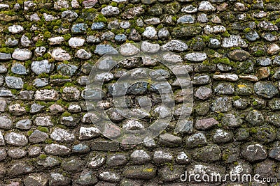 Old stone wall covered with clumps of green moss and lichen Stock Photo