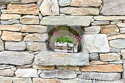 Old stone wall decorated with flowers Stock Photo