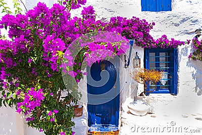 Old streets with pink flowers and blue doors. Greece Editorial Stock Photo