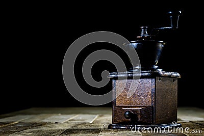 Old stylish grinder for grinding tasty coffee on an old wooden t Stock Photo