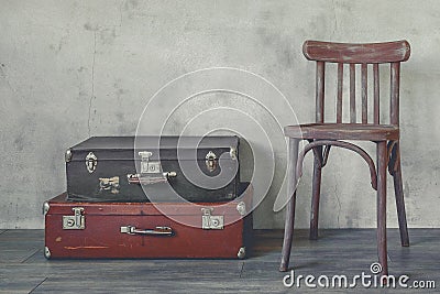 Old suitcase and a wooden chair Stock Photo