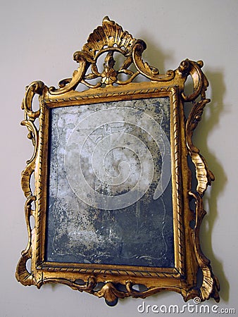 old tarnished gold framed mirror with ornate baroque details Stock Photo