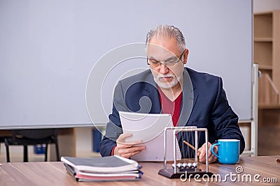 Old teacher physicist sitting in the classroom Stock Photo