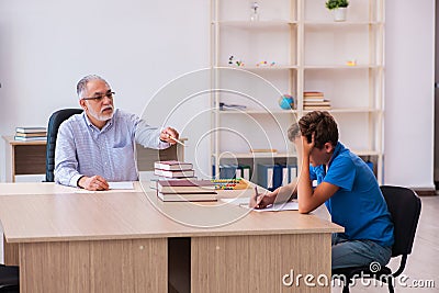 Old male teacher and schoolboy in the classroom Stock Photo