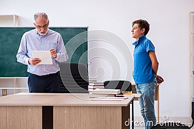 Old male teacher and schoolboy in the classroom Stock Photo