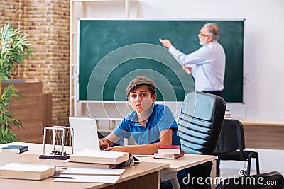 Old male teacher and schoolboy in the classroom Stock Photo