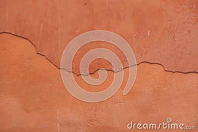 Old terracotta painted stucco wall with cracked plaster. Background texture Stock Photo