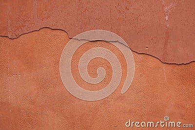 Old terracotta painted stucco wall with cracked plaster. Background texture Stock Photo
