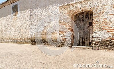 Old textured wooden door on the facade of a town house in Spain. Stock Photo