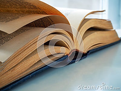 An old thick book with yellow pages is open and lies on the table. Background for libraries and education Stock Photo