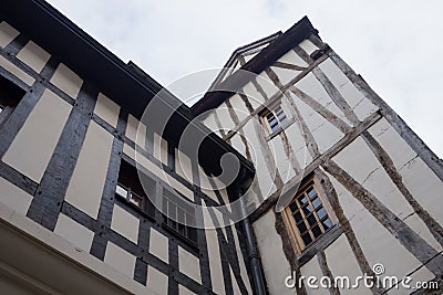 Old and tilted houses at Rue Eau de Robec in Rouen on a rainy day. Rue Eau-de-Robec is one of the main tourist streets Editorial Stock Photo