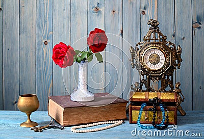 Old timepiece, books, flowers and jewelry Stock Photo