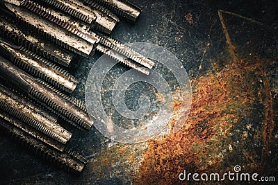Old tools ,Taps and Dies, Cutting Tools for hand or machine tapping of through or blind holes on rusty metal plate background at Stock Photo