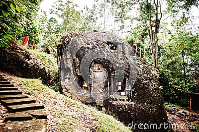 Old torajan burial site in Bori, Tana Toraja. The cemetery with coffins placed in a huge stone. Indonesia, Rantapao, Sulawesi Editorial Stock Photo