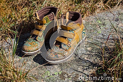 Old tourists boots on stone near mountain stream Stock Photo